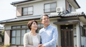 マイホームの前に高齢夫婦が立っている